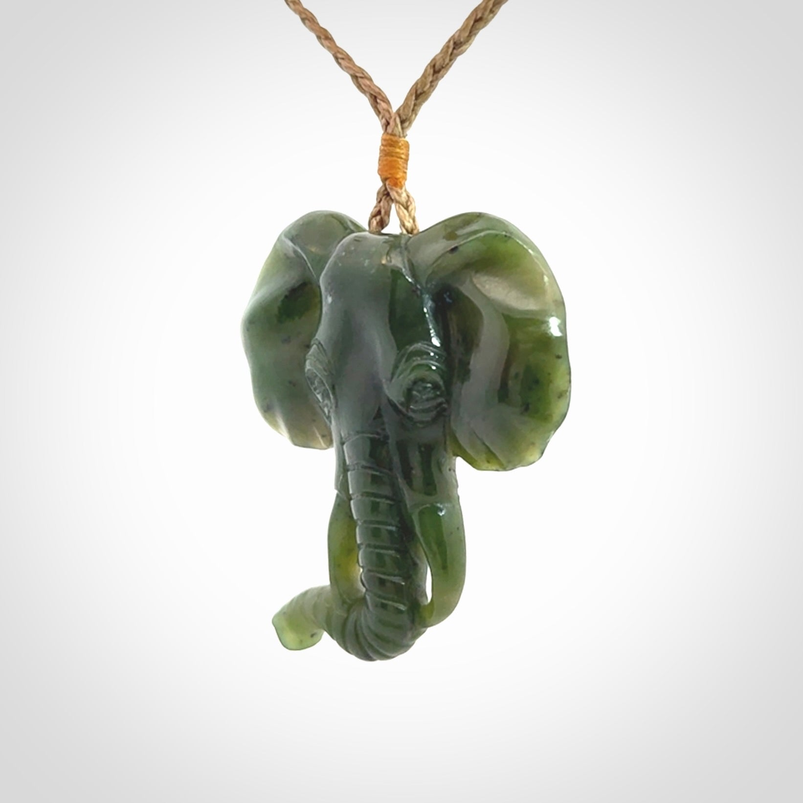 This is a hand made elephant pendant. Carved in a beautiful darker green piece of British Columbian jade. The cord is hand-plaited in a tan colour and is length adjustable. Provided in a woven kete pouch and delivered with express courier.