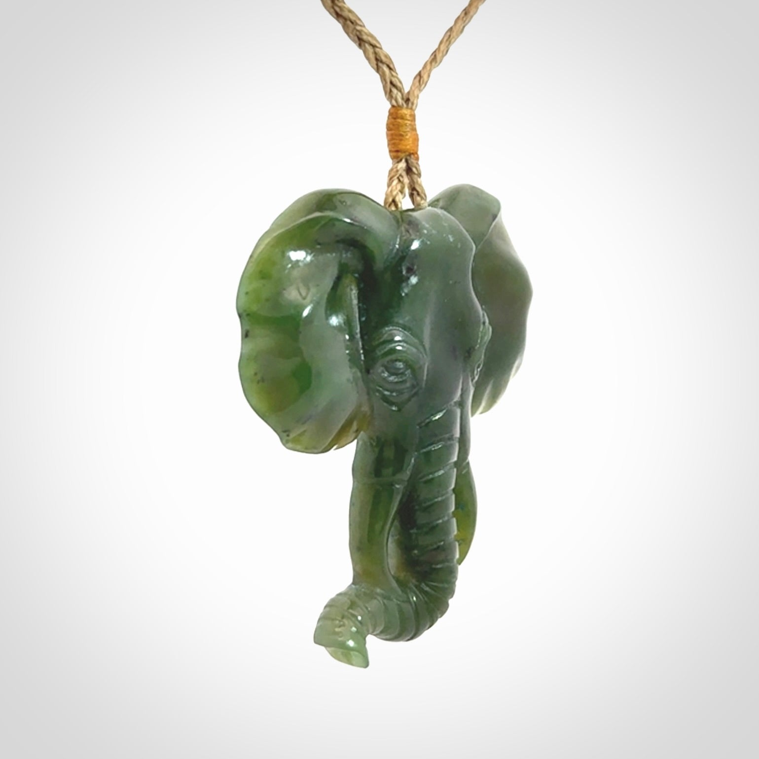 This is a hand made elephant pendant. Carved in a beautiful darker green piece of British Columbian jade. The cord is hand-plaited in a tan colour and is length adjustable. Provided in a woven kete pouch and delivered with express courier.