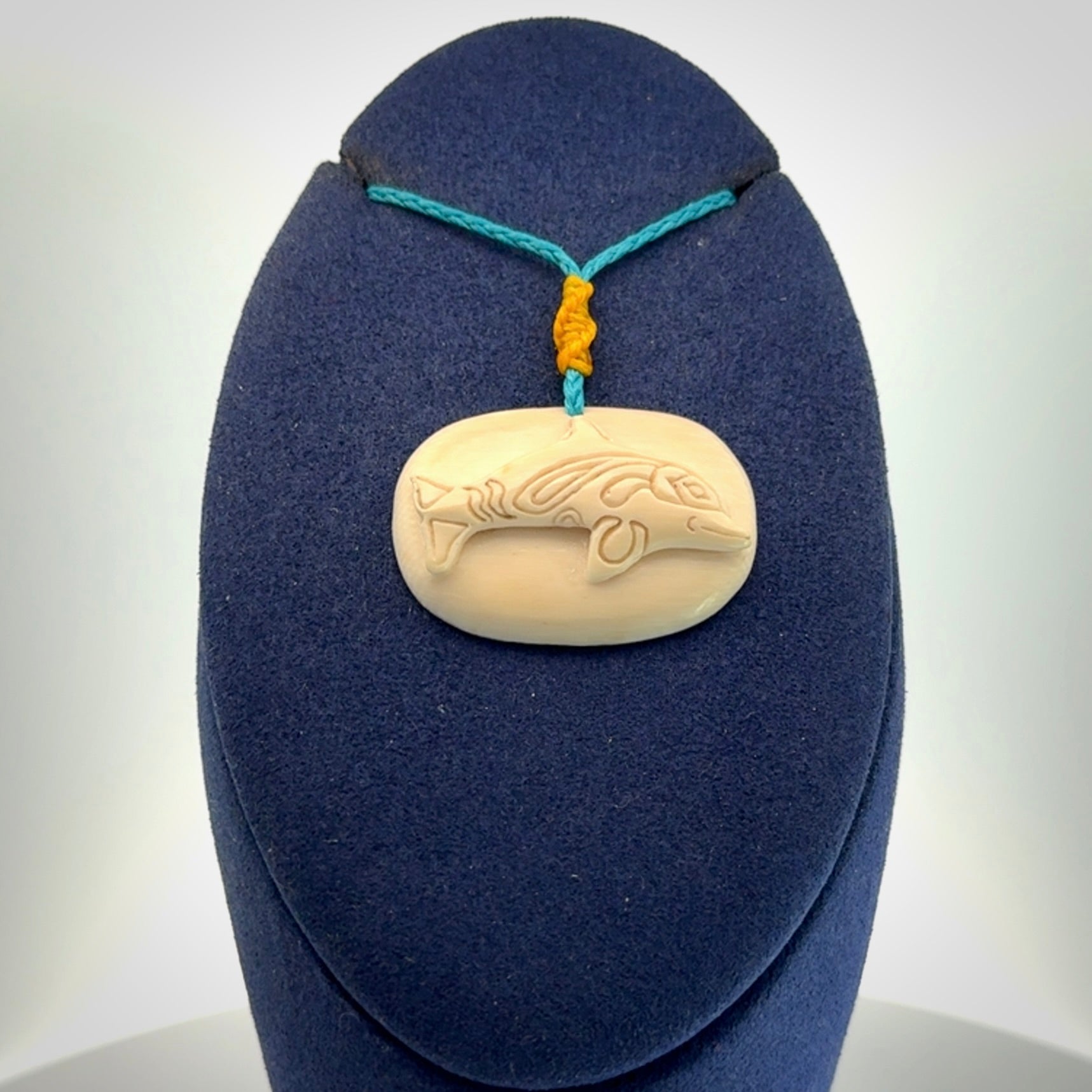 A beautiful dolphin pendant carved in mammoth tusk