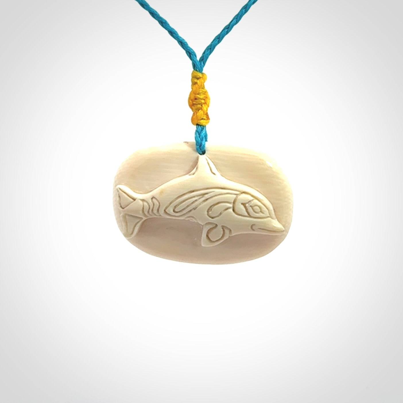 A beautiful dolphin pendant carved in mammoth tusk