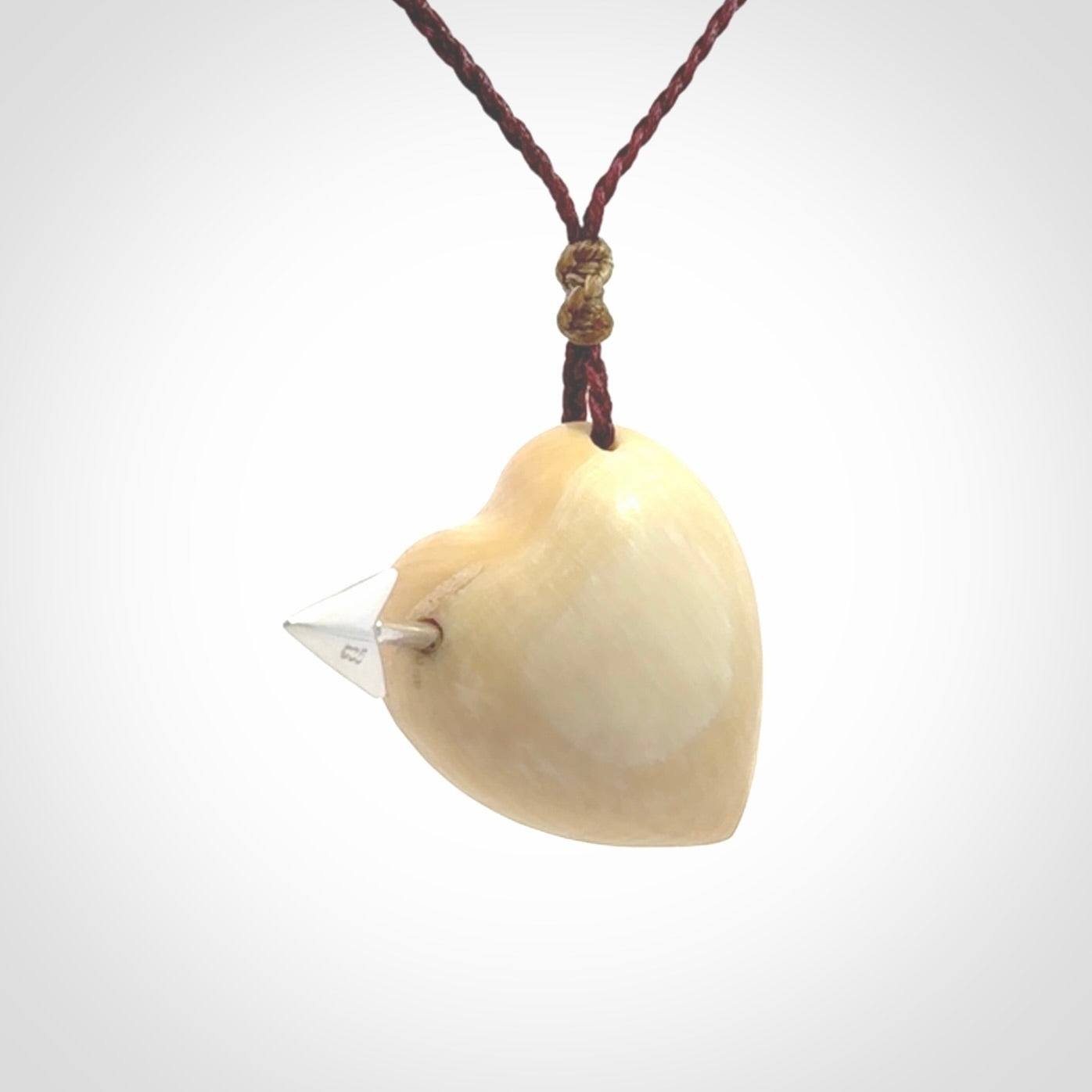 Hand crafted contemporary woolly mammoth tusk heart with sterling silver arrow necklace. This necklace is provided with an adjustable plum cord.