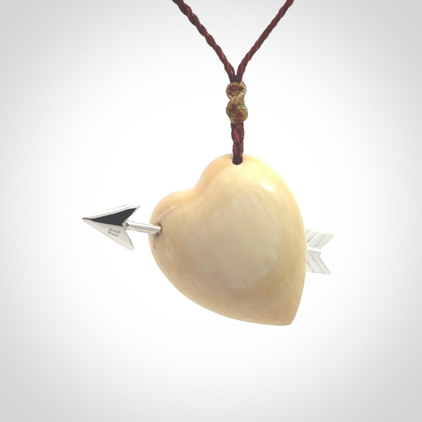 Hand crafted contemporary woolly mammoth tusk heart with sterling silver arrow necklace. This necklace is provided with an adjustable plum cord.