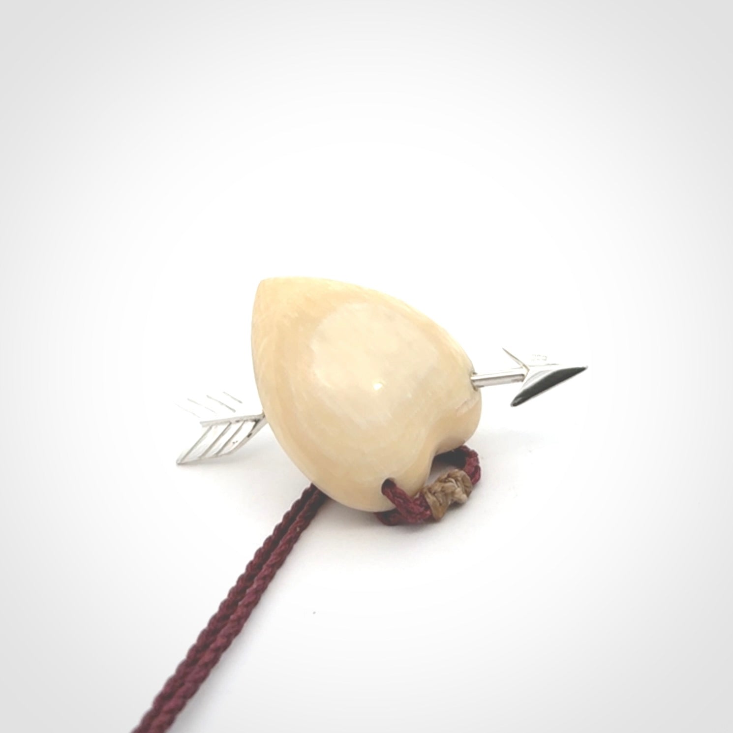 Hand crafted contemporary woolly mammoth tusk heart with sterling silver arrow necklace. This necklace is provided with an adjustable plum cord.