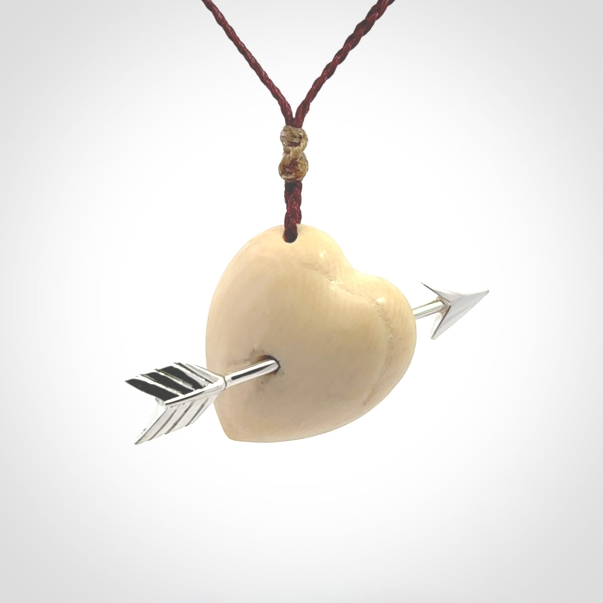 Hand crafted contemporary woolly mammoth tusk heart with sterling silver arrow necklace. This necklace is provided with an adjustable plum cord.
