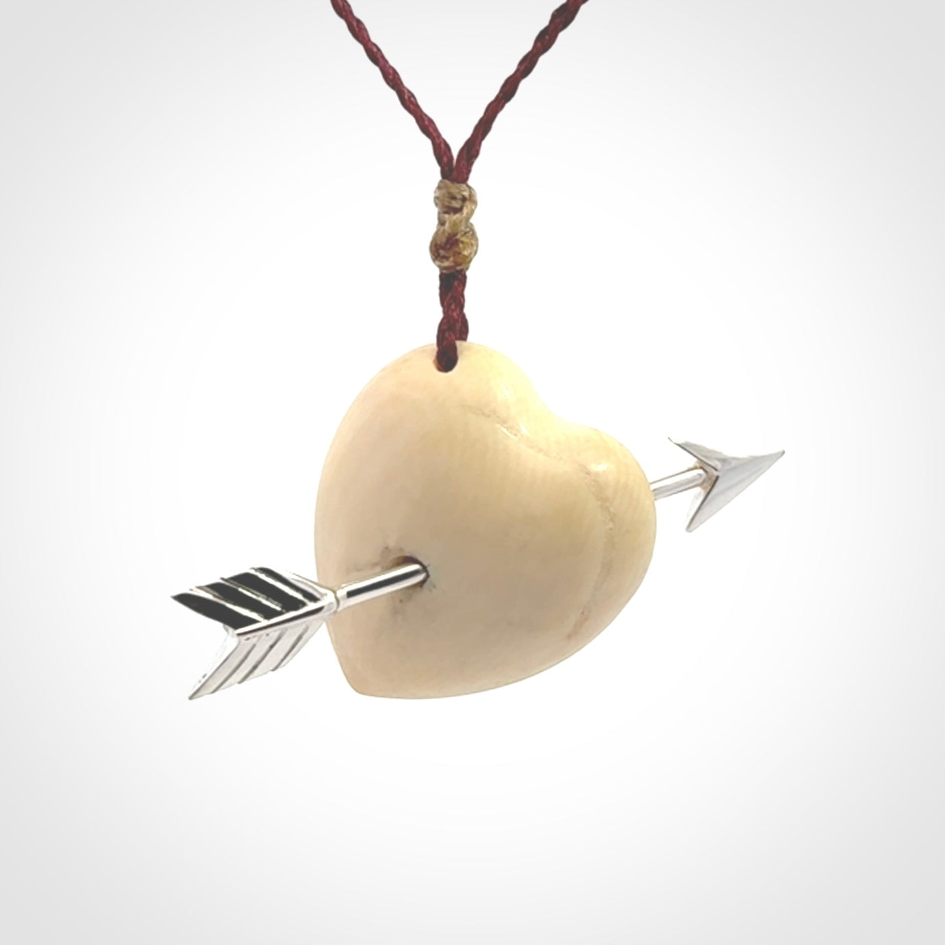 Hand crafted contemporary woolly mammoth tusk heart with sterling silver arrow necklace. This necklace is provided with an adjustable plum cord.