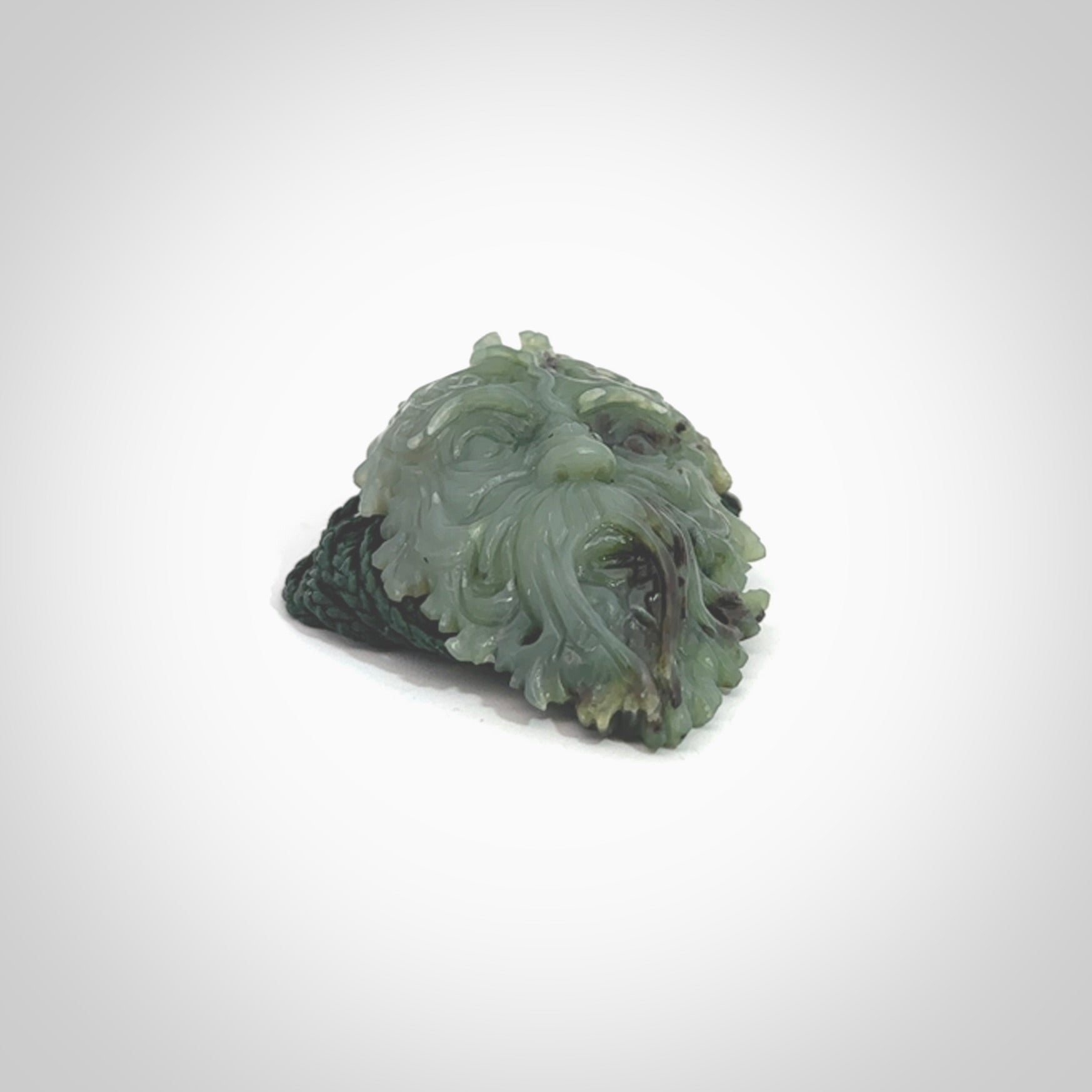 This picture shows a large hand carved forest man face pendant. It is a light green colour which is quite beautiful. Although a large piece, it is a wonderful, delicate piece of jewellery. The cord is hand plaited and adjustable so that you can position the pendant where it suits you best. Delivery is free worldwide.