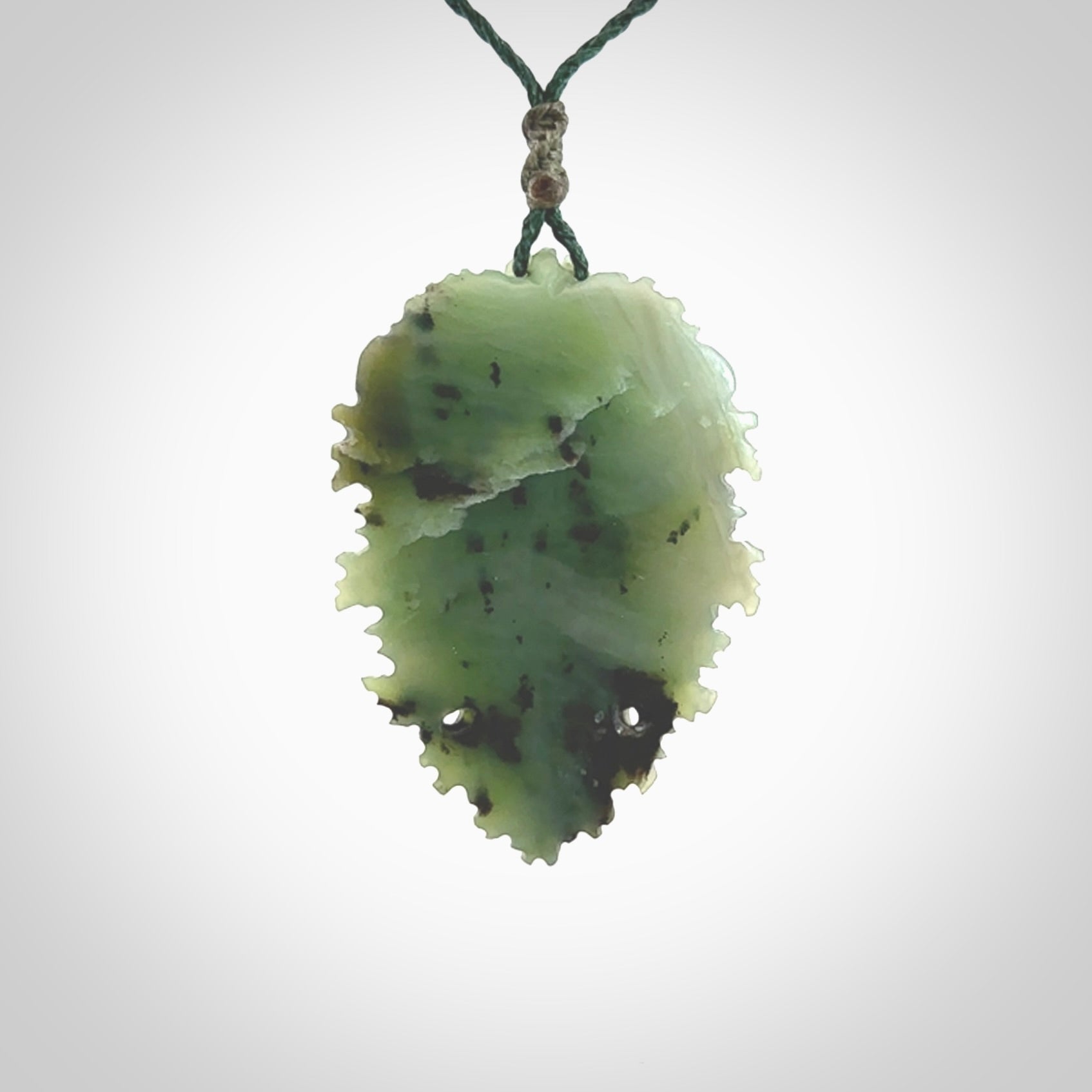 This picture shows a large hand carved forest man face pendant. It is a light green colour which is quite beautiful. Although a large piece, it is a wonderful, delicate piece of jewellery. The cord is hand plaited and adjustable so that you can position the pendant where it suits you best. Delivery is free worldwide.