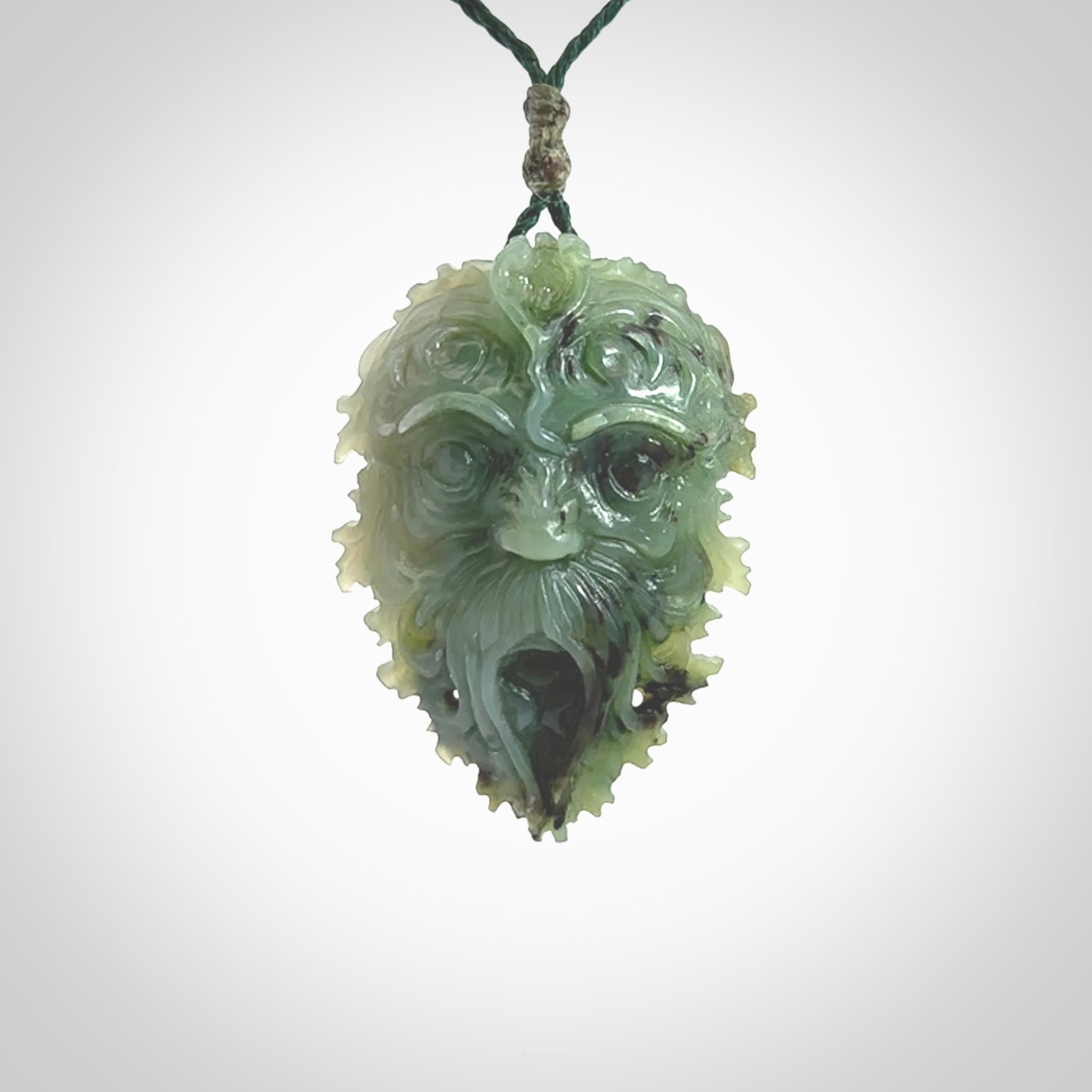 This picture shows a large hand carved forest man face pendant. It is a light green colour which is quite beautiful. Although a large piece, it is a wonderful, delicate piece of jewellery. The cord is hand plaited and adjustable so that you can position the pendant where it suits you best. Delivery is free worldwide.