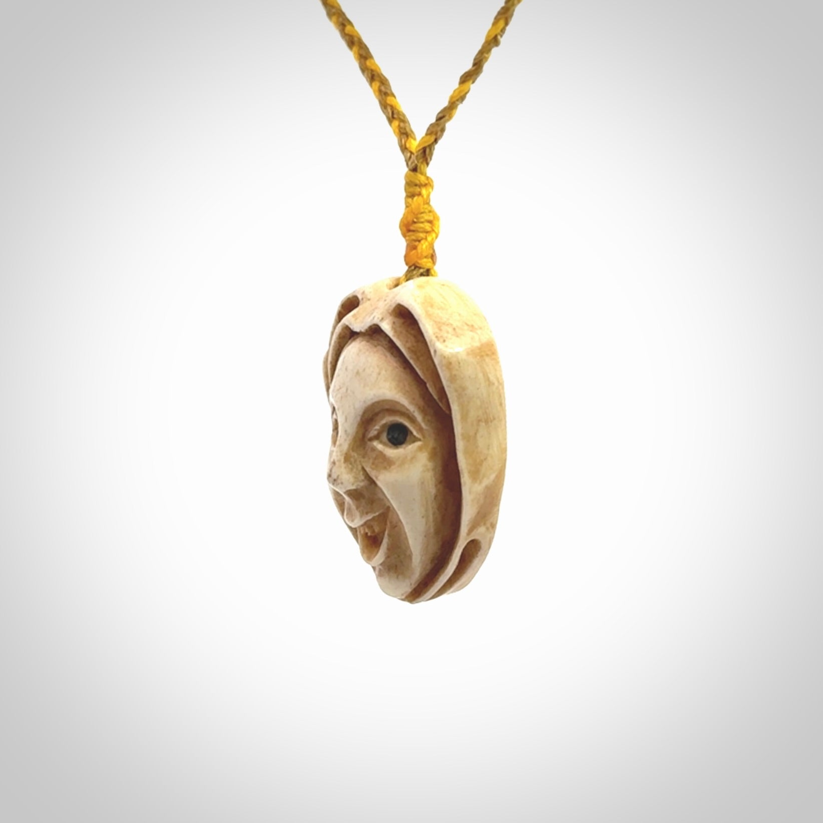 Hand carved incredible stained bone gargoyle face carving. A stunning work of art. This pendant was hand carved in bone with buffalo horn inlay for the eyes by Yuri Terenyi. A one off collectors item that has been hand crafted to be worn or displayed.