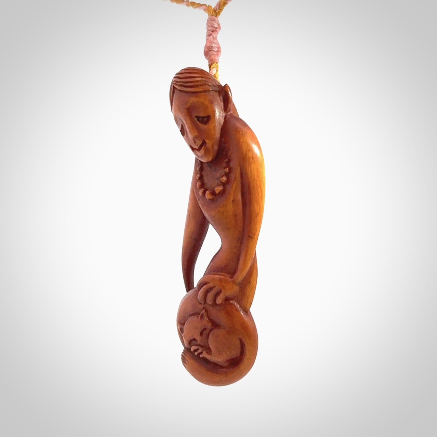 Hand carved stained bone female pendant in a repose shape with her cat. Made from natural bone. Bone jewellery from the Pacific for sale online. Female pendant for men and women.