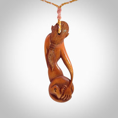 Hand carved stained bone female pendant in a repose shape with her cat. Made from natural bone. Bone jewellery from the Pacific for sale online. Female pendant for men and women.