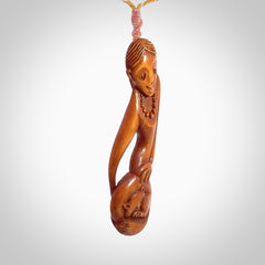 Hand carved stained bone female pendant in a repose shape with her cat. Made from natural bone. Bone jewellery from the Pacific for sale online. Female pendant for men and women.