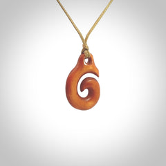 Stained natural cow bone hook with koru pendant. Hand carved by Yuri Terenyi in New Zealand. Koru design pendant for sale online. Stained bone koru necklace with adjustable cord. Free delivery worldwide.