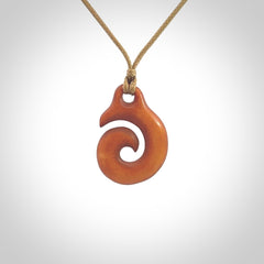 Stained natural cow bone hook with koru pendant. Hand carved by Yuri Terenyi in New Zealand. Koru design pendant for sale online. Stained bone koru necklace with adjustable cord. Free delivery worldwide.
