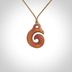 Stained natural cow bone hook with koru pendant. Hand carved by Yuri Terenyi in New Zealand. Koru design pendant for sale online. Stained bone koru necklace with adjustable cord. Free delivery worldwide.