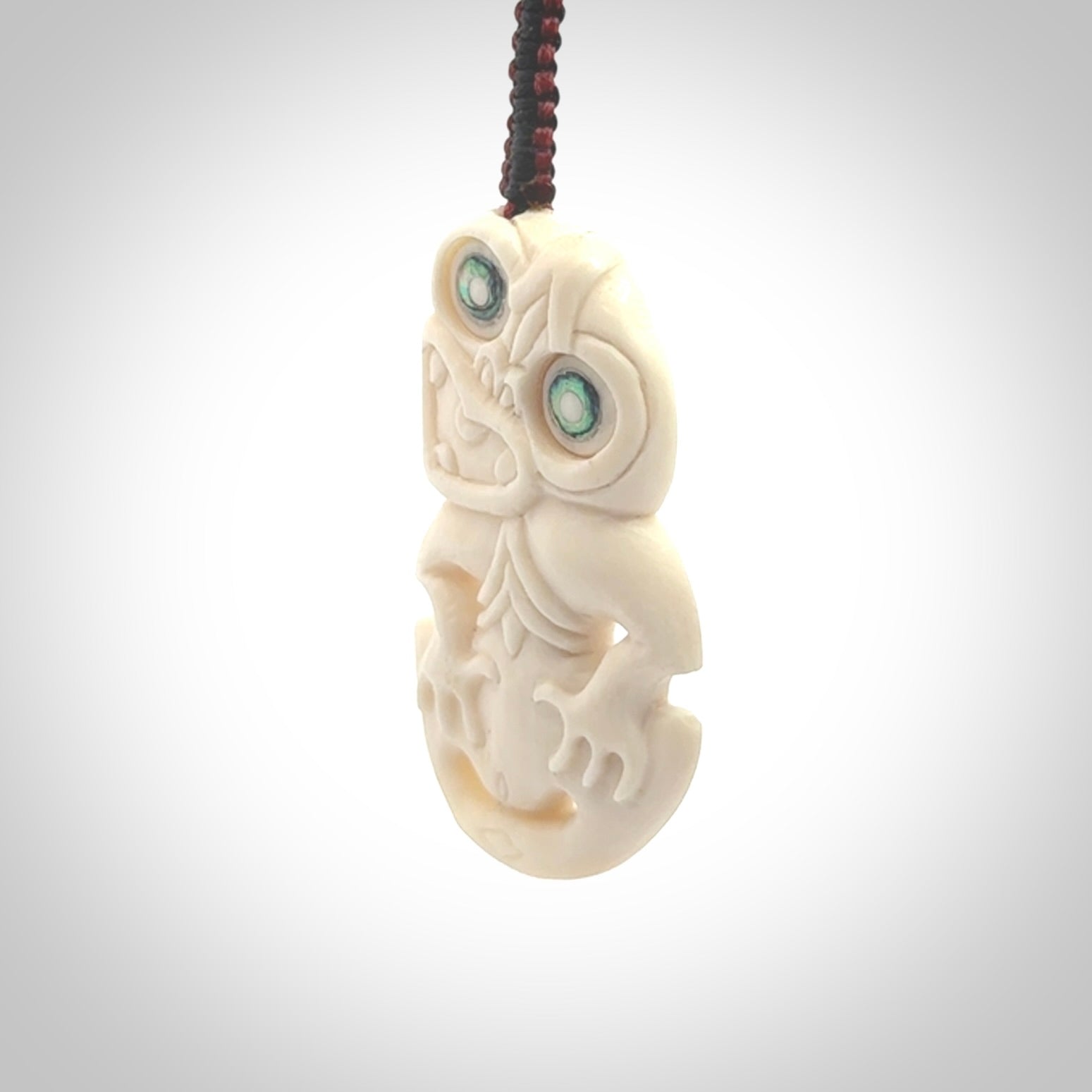 Hand carved bone Tiki pendant. Traditional art hand carved for NZ Pacific. Whalebone Tiki necklace with Paua Shell eyes. Free worldwide delivery. Provided to you on a hand plaited adjustable cord.