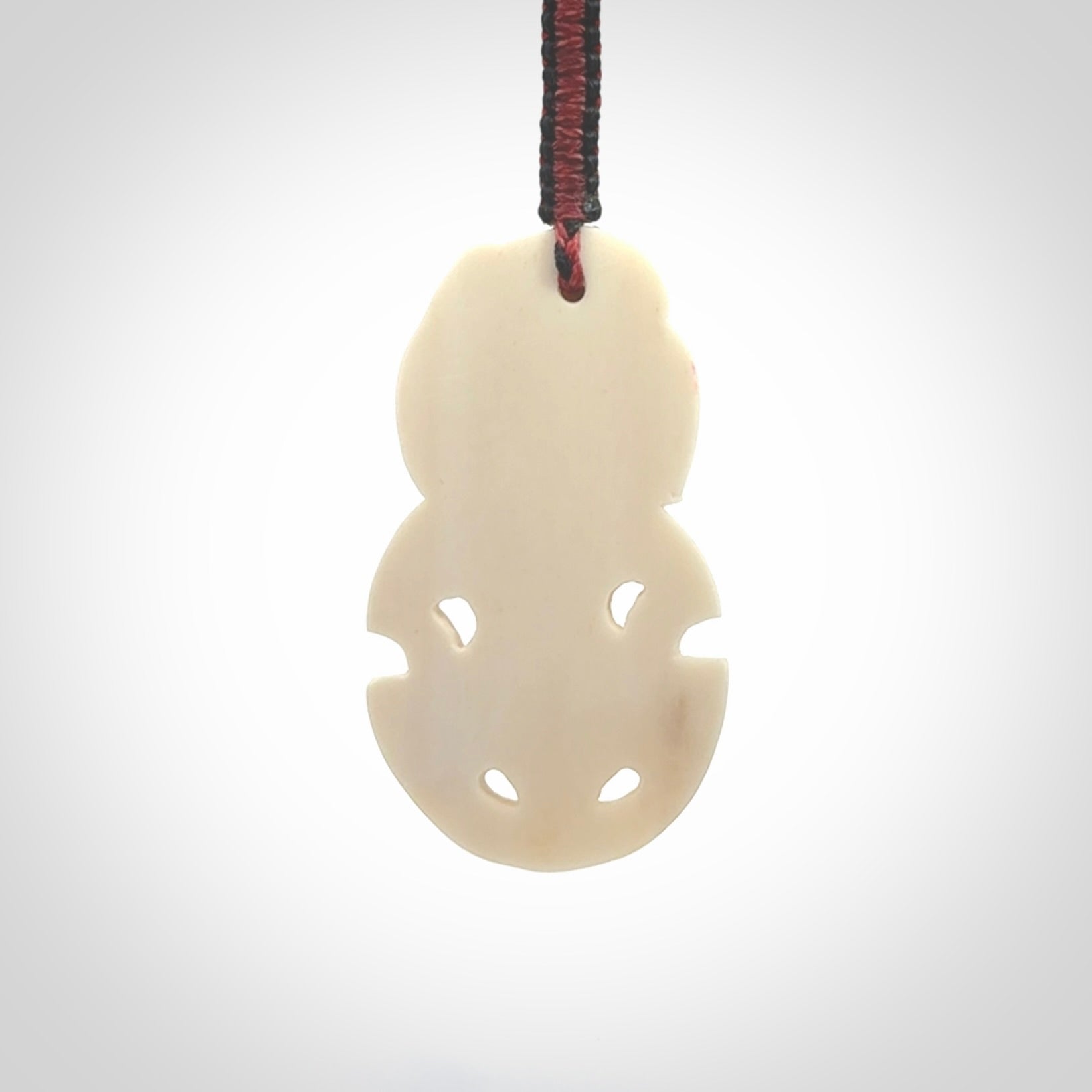 Hand carved bone Tiki pendant. Traditional art hand carved for NZ Pacific. Whalebone Tiki necklace with Paua Shell eyes. Free worldwide delivery. Provided to you on a hand plaited adjustable cord.