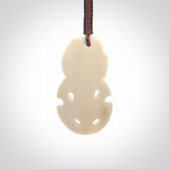Hand carved bone Tiki pendant. Traditional art hand carved for NZ Pacific. Whalebone Tiki necklace with Paua Shell eyes. Free worldwide delivery. Provided to you on a hand plaited adjustable cord.