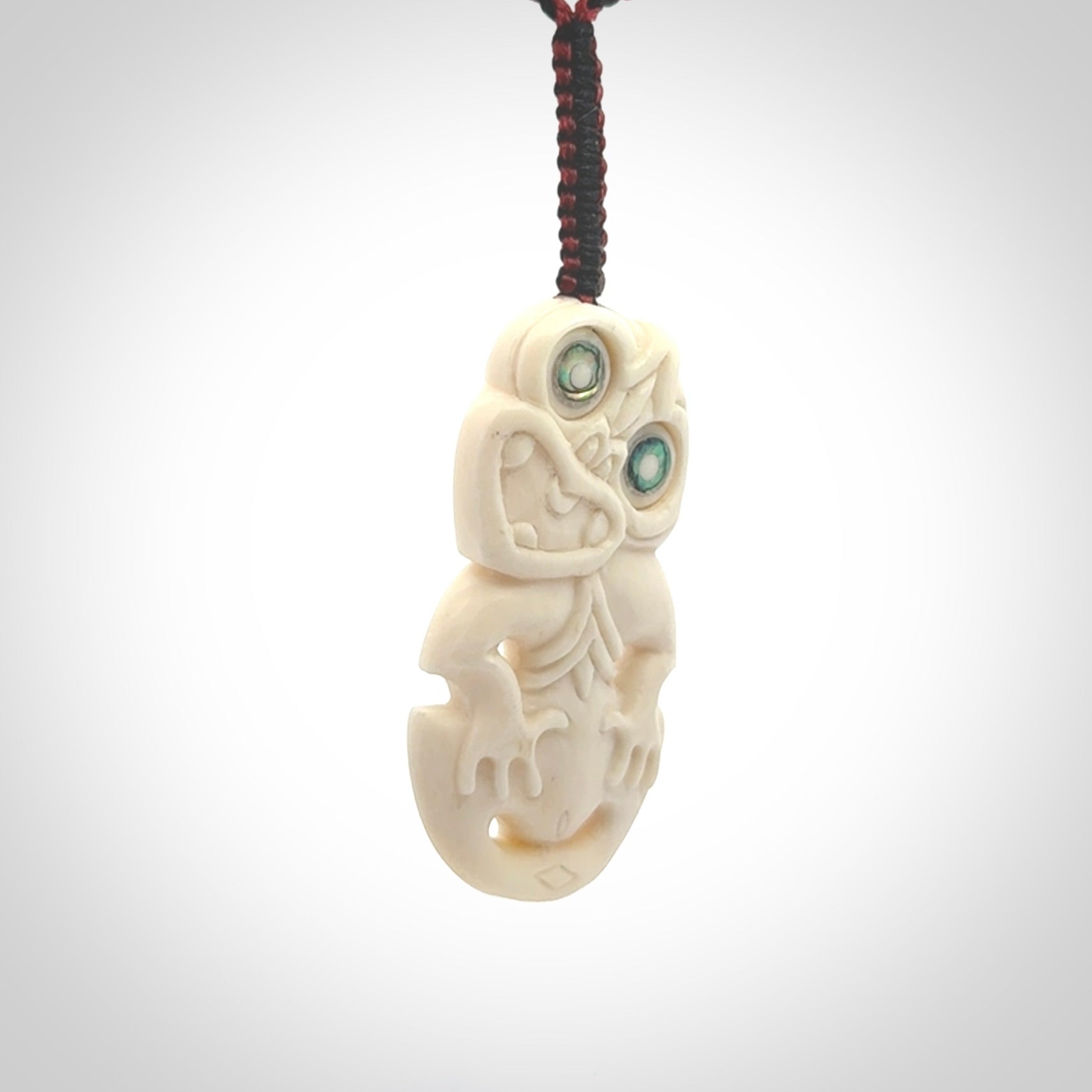 Hand carved bone Tiki pendant. Traditional art hand carved for NZ Pacific. Whalebone Tiki necklace with Paua Shell eyes. Free worldwide delivery. Provided to you on a hand plaited adjustable cord.