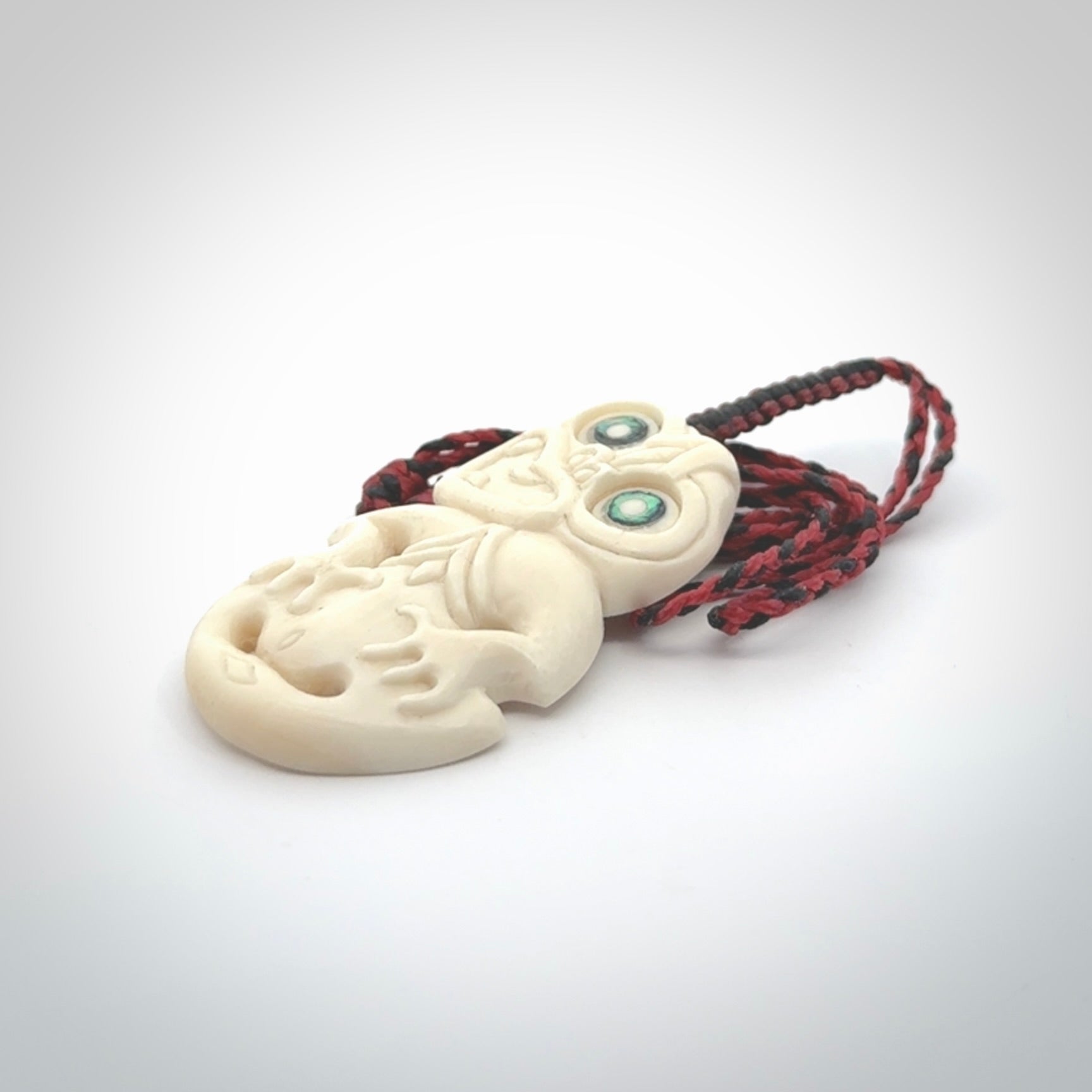 Hand carved bone Tiki pendant. Traditional art hand carved for NZ Pacific. Whalebone Tiki necklace with Paua Shell eyes. Free worldwide delivery. Provided to you on a hand plaited adjustable cord.