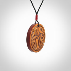 Hand carved natural stained bone contemporary disc pendant with creative and unique carvings on the front face of each individual piece.