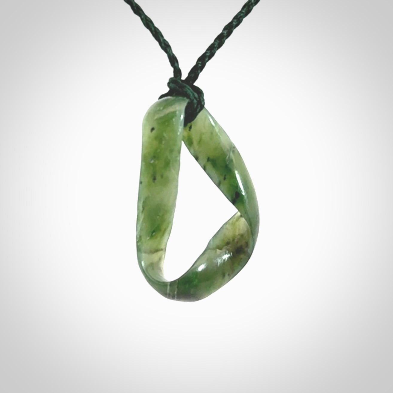 This little piece is a hand carved möbius ribbon pendant. We've carved this from Nephrite Jade. It has very subtle colour variations in the stone and is a delightful, small and artistic piece of jewellery.