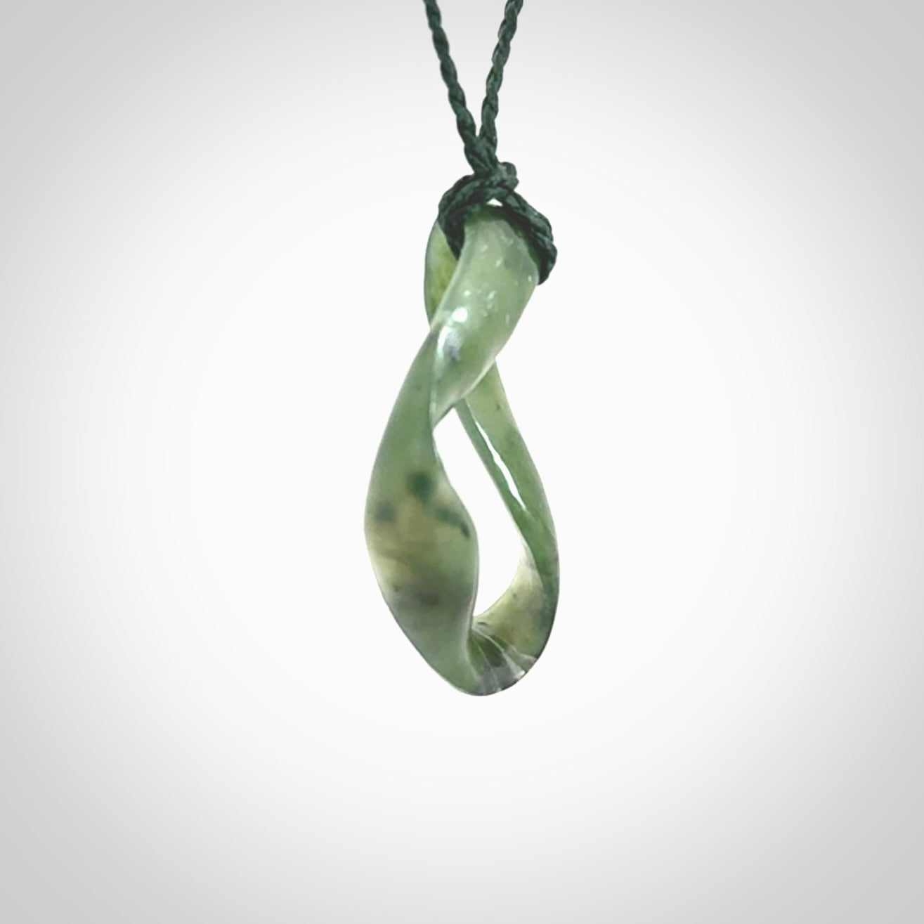 This little piece is a hand carved möbius ribbon pendant. We've carved this from Nephrite Jade. It has very subtle colour variations in the stone and is a delightful, small and artistic piece of jewellery.