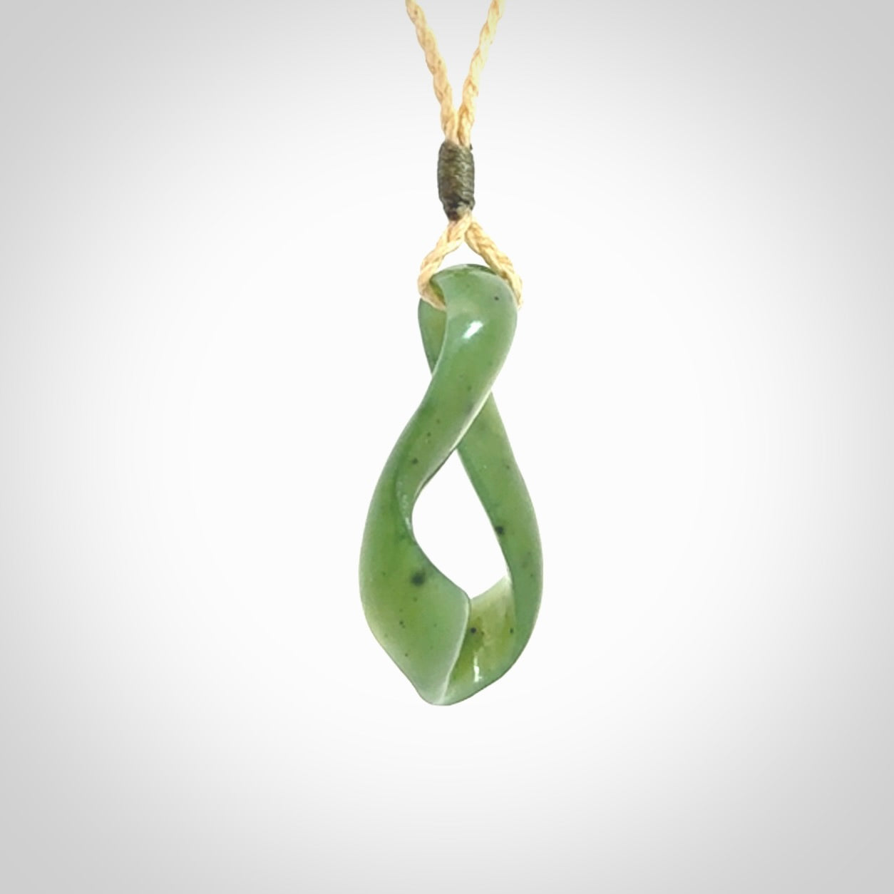 This little piece is a hand carved möbius ribbon pendant. We've carved this from Nephrite Jade. It has very subtle colour variations in the stone and is a delightful, small and artistic piece of jewellery.