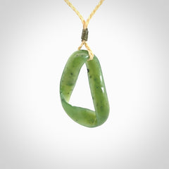 This little piece is a hand carved möbius ribbon pendant. We've carved this from Nephrite Jade. It has very subtle colour variations in the stone and is a delightful, small and artistic piece of jewellery.