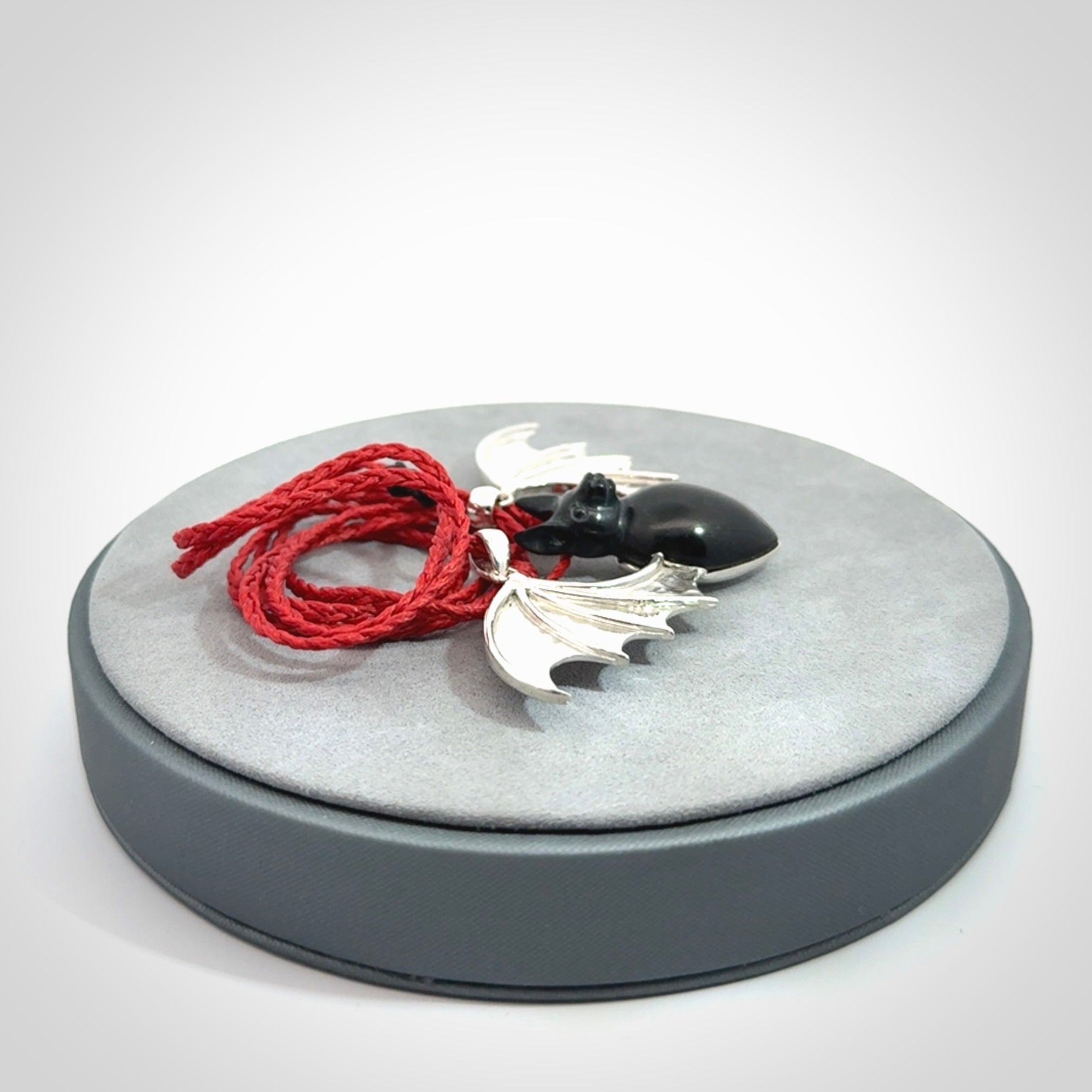 This is a hand carved bat pendant. It is made from Black Jade and Sterling Silver. This is a medium sized necklace and is a very unique, one only, pendant that is a collectors piece. Provided with red adjustable cord.