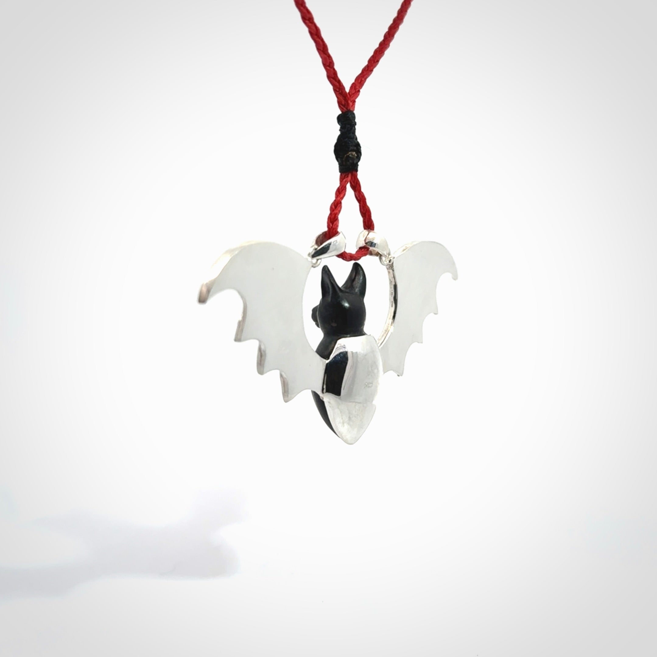 This is a hand carved bat pendant. It is made from Black Jade and Sterling Silver. This is a medium sized necklace and is a very unique, one only, pendant that is a collectors piece. Provided with red adjustable cord.