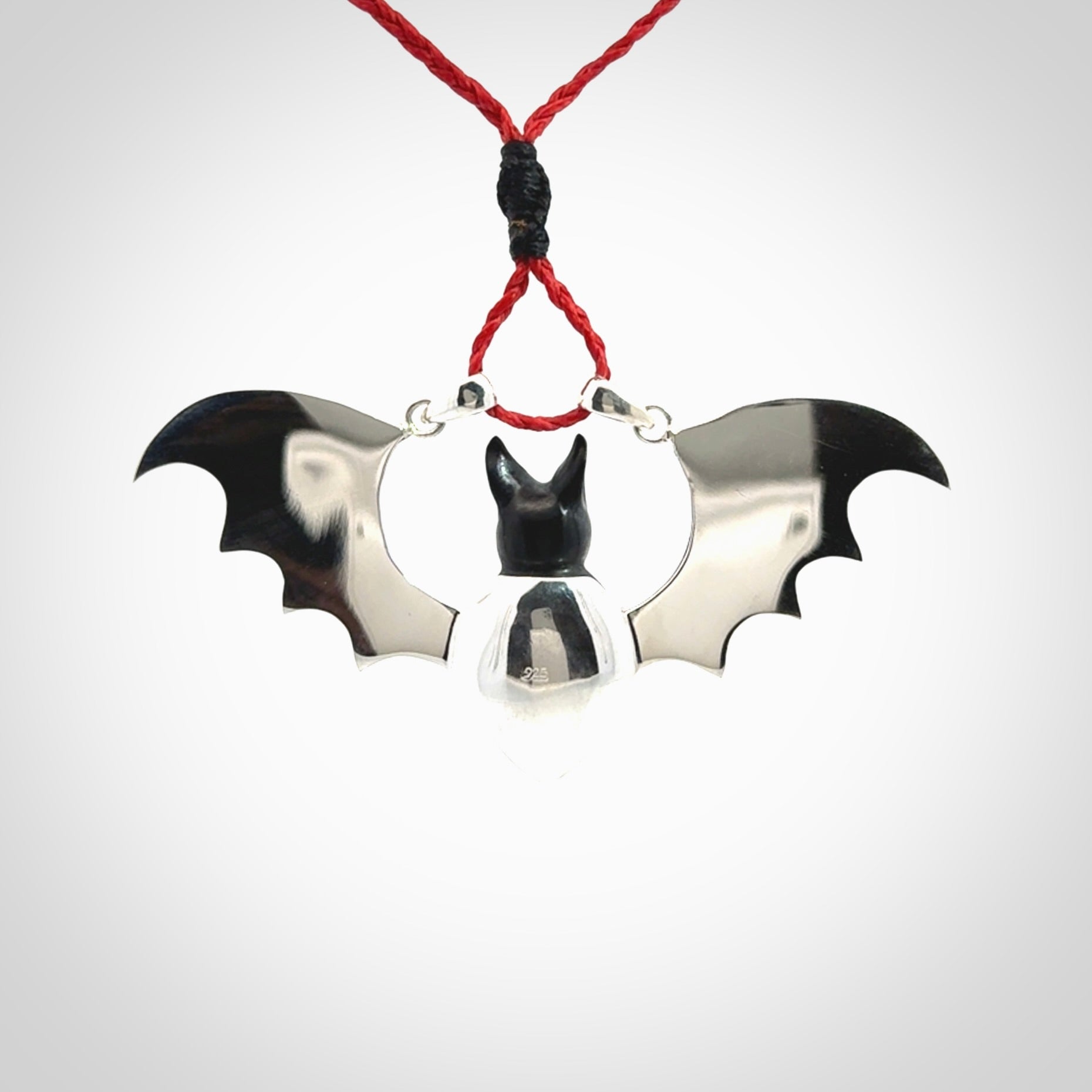 This is a hand carved bat pendant. It is made from Black Jade and Sterling Silver. This is a medium sized necklace and is a very unique, one only, pendant that is a collectors piece. Provided with red adjustable cord.