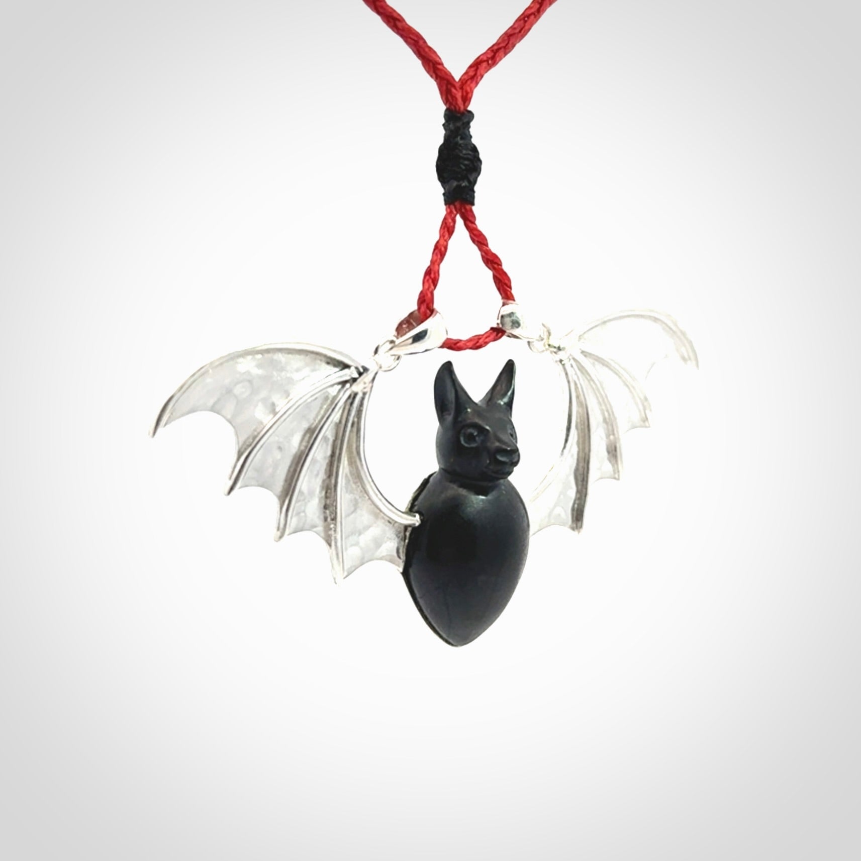 This is a hand carved bat pendant. It is made from Black Jade and Sterling Silver. This is a medium sized necklace and is a very unique, one only, pendant that is a collectors piece. Provided with red adjustable cord.