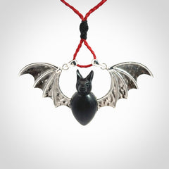 This is a hand carved bat pendant. It is made from Black Jade and Sterling Silver. This is a medium sized necklace and is a very unique, one only, pendant that is a collectors piece. Provided with red adjustable cord.