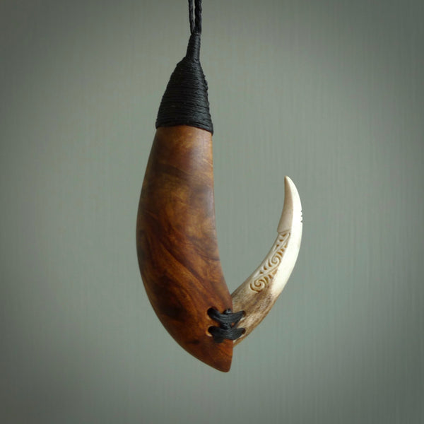 This picture shows a large matau, hook called a pā kahawai. It is carved from deer antler bone, wood, and paua shell. One only, free shipping worldwide. Provided with an adjustable black cord. Stunning work of Art to Wear by Fumio Noguchi.