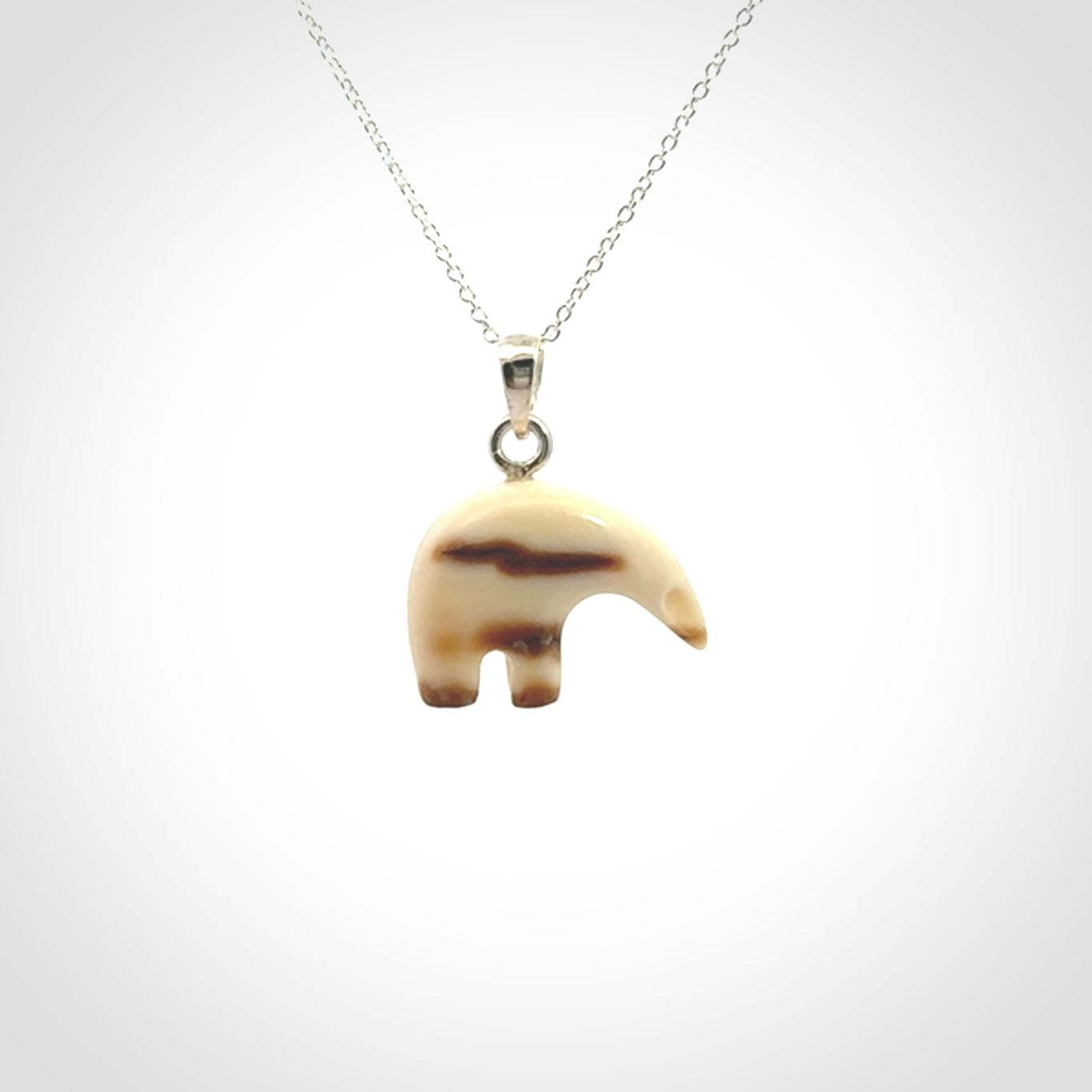 Hand made woolly mammoth tusk sea bear necklace with Sterling Silver. Mammoth tusk polar bear pendant with Sterling silver surround and chain. Made by NZ Pacific and sale online only.