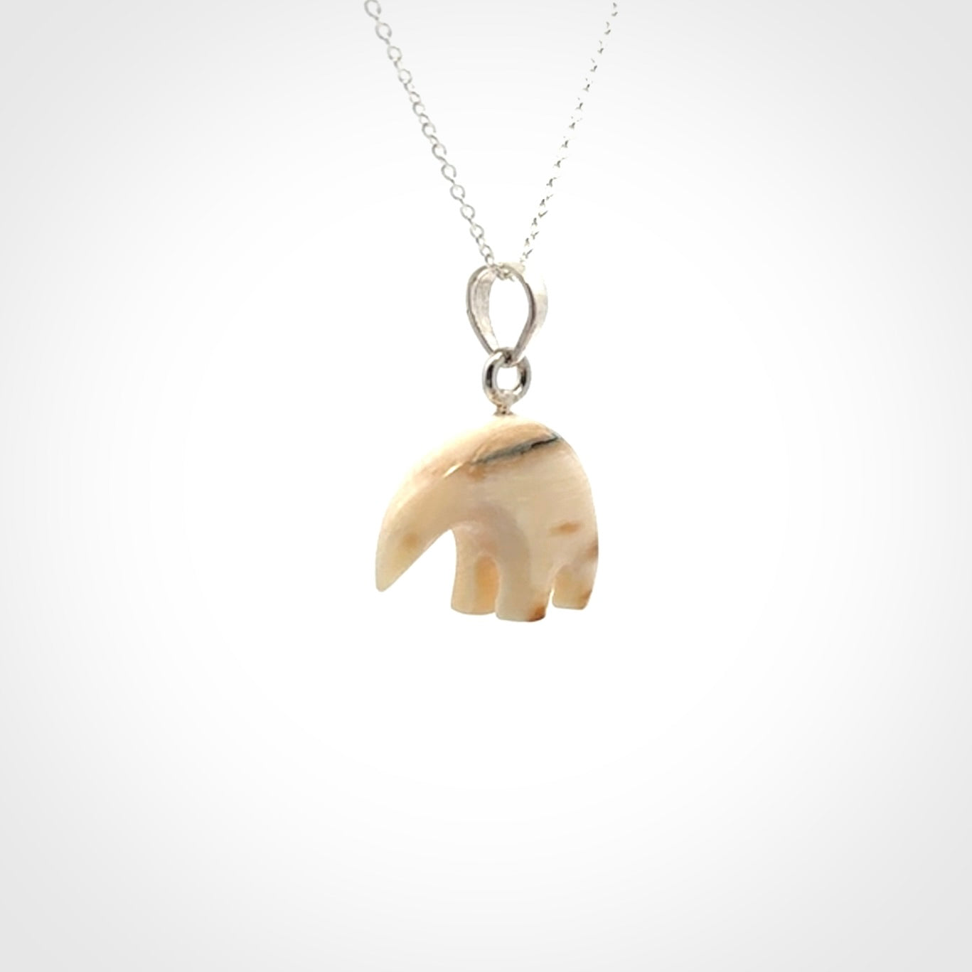 Hand made woolly mammoth tusk sea bear necklace with Sterling Silver. Mammoth tusk polar bear pendant with Sterling silver surround and chain. Made by NZ Pacific and sale online only.