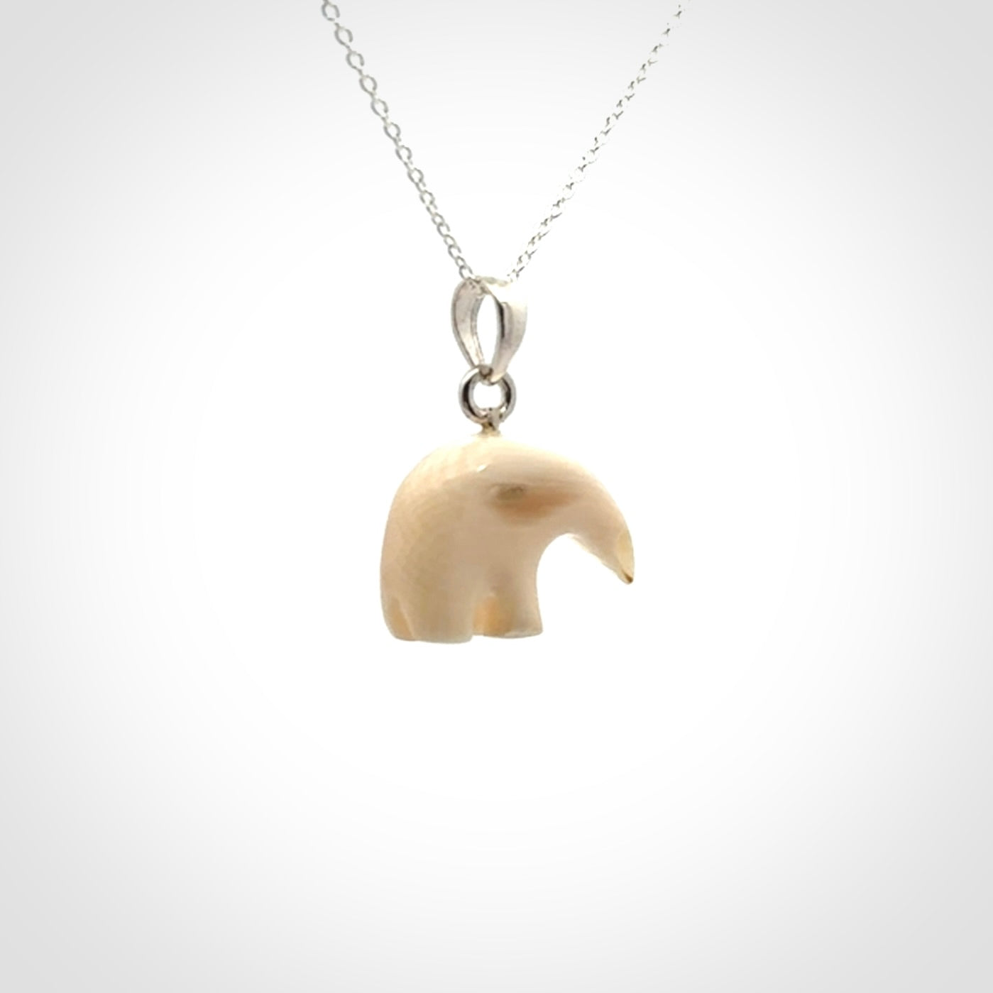Hand made woolly mammoth tusk sea bear necklace with Sterling Silver. Mammoth tusk polar bear pendant with Sterling silver surround and chain. Made by NZ Pacific and sale online only.