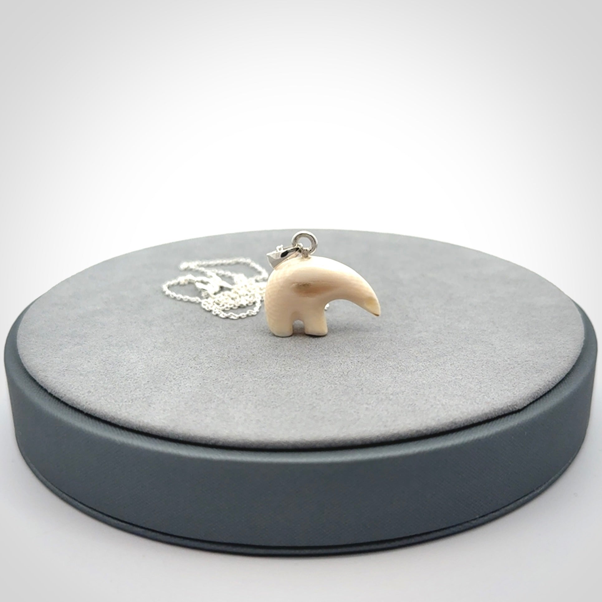 Hand made woolly mammoth tusk sea bear necklace with Sterling Silver. Mammoth tusk polar bear pendant with Sterling silver surround and chain. Made by NZ Pacific and sale online only.