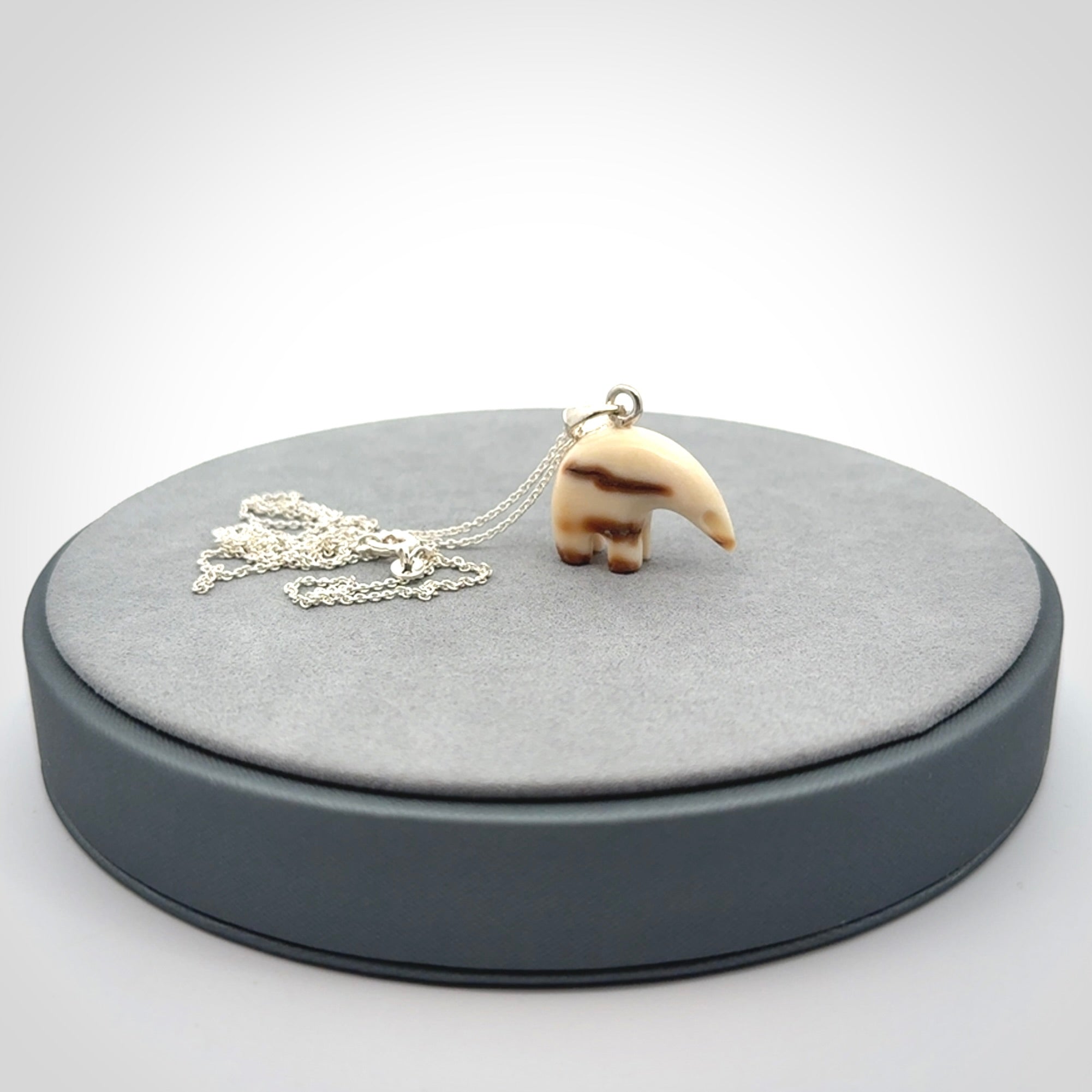 Hand made woolly mammoth tusk sea bear necklace with Sterling Silver. Mammoth tusk polar bear pendant with Sterling silver surround and chain. Made by NZ Pacific and sale online only.