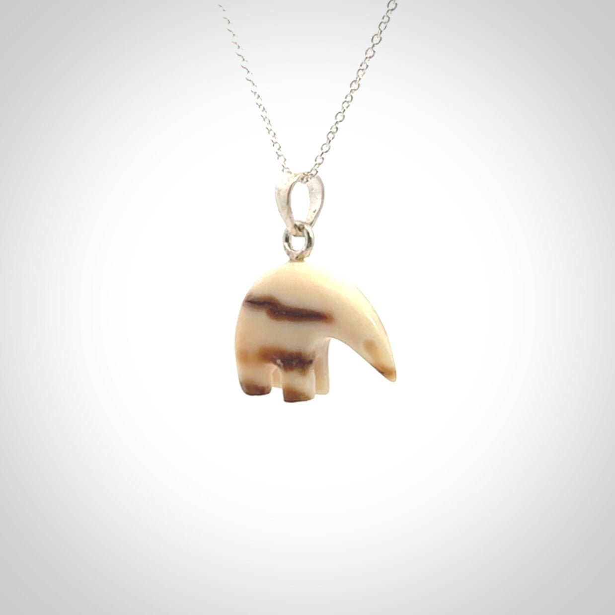 Hand made woolly mammoth tusk sea bear necklace with Sterling Silver. Mammoth tusk polar bear pendant with Sterling silver surround and chain. Made by NZ Pacific and sale online only.