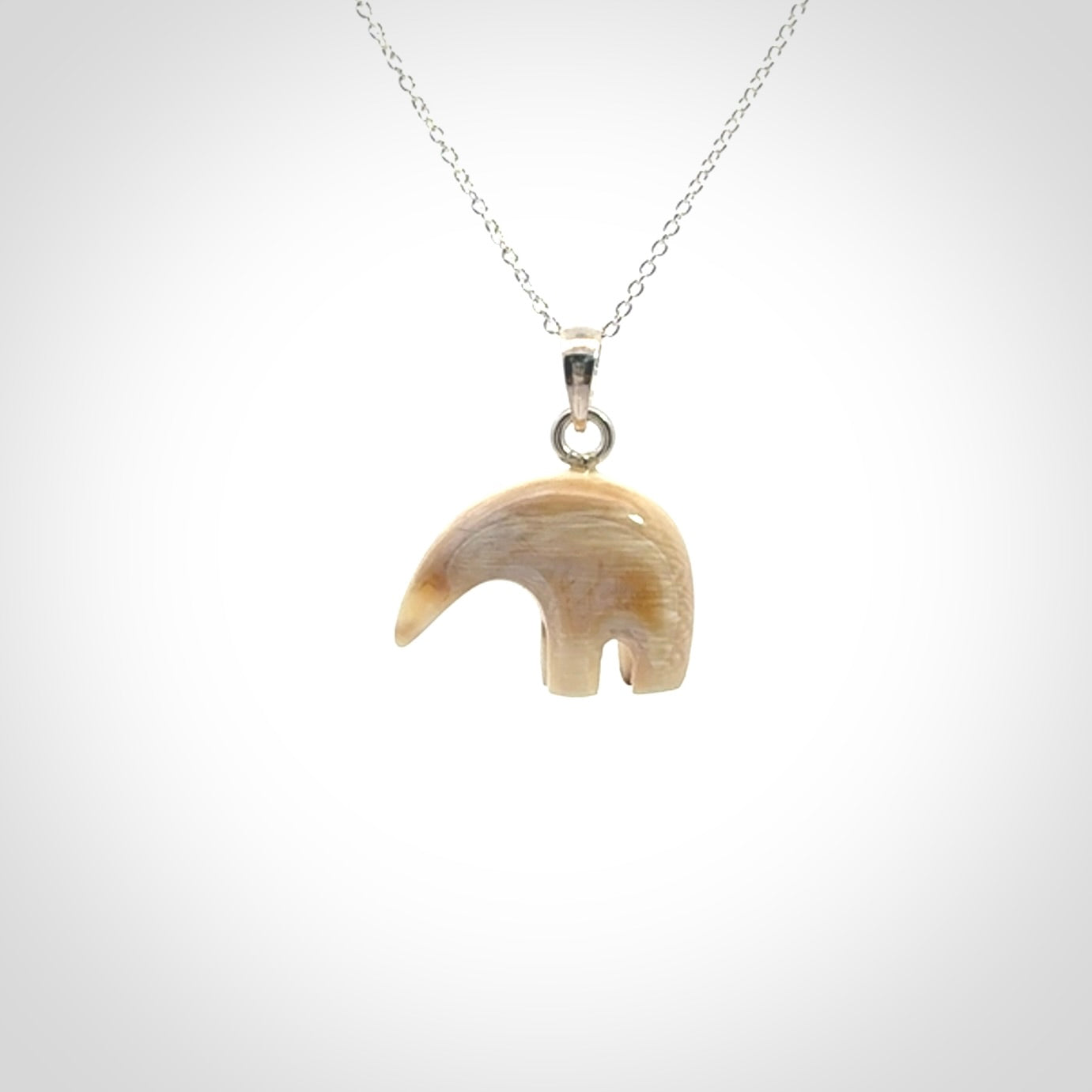 Hand made woolly mammoth tusk sea bear necklace with Sterling Silver. Mammoth tusk polar bear pendant with Sterling silver surround and chain. Made by NZ Pacific and sale online only.