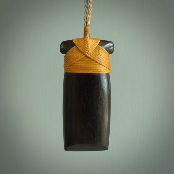 This photo shows wooden toki pendants. The cord is length adjustable which allows the pendant to be positioned where it suits you best. The toki was carved for us in hard wood. Unique art to wear.