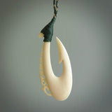 Natural cow bone hook with Manaia pendant. Hand carved by Yuri Terenyi in New Zealand. Maori design pendant for sale online. Natural bone manaia, hook necklace. Free delivery worldwide.