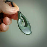 A hand carved large sized contemporary kour pendant. This is a piece of genuine jade jewellery, hand carved by Ric Moor. He has used New Zealand jade and has utilised his experience and carving skill to highlight the natural beauty of the stone. Delivered worldwide, postage is included in the price.