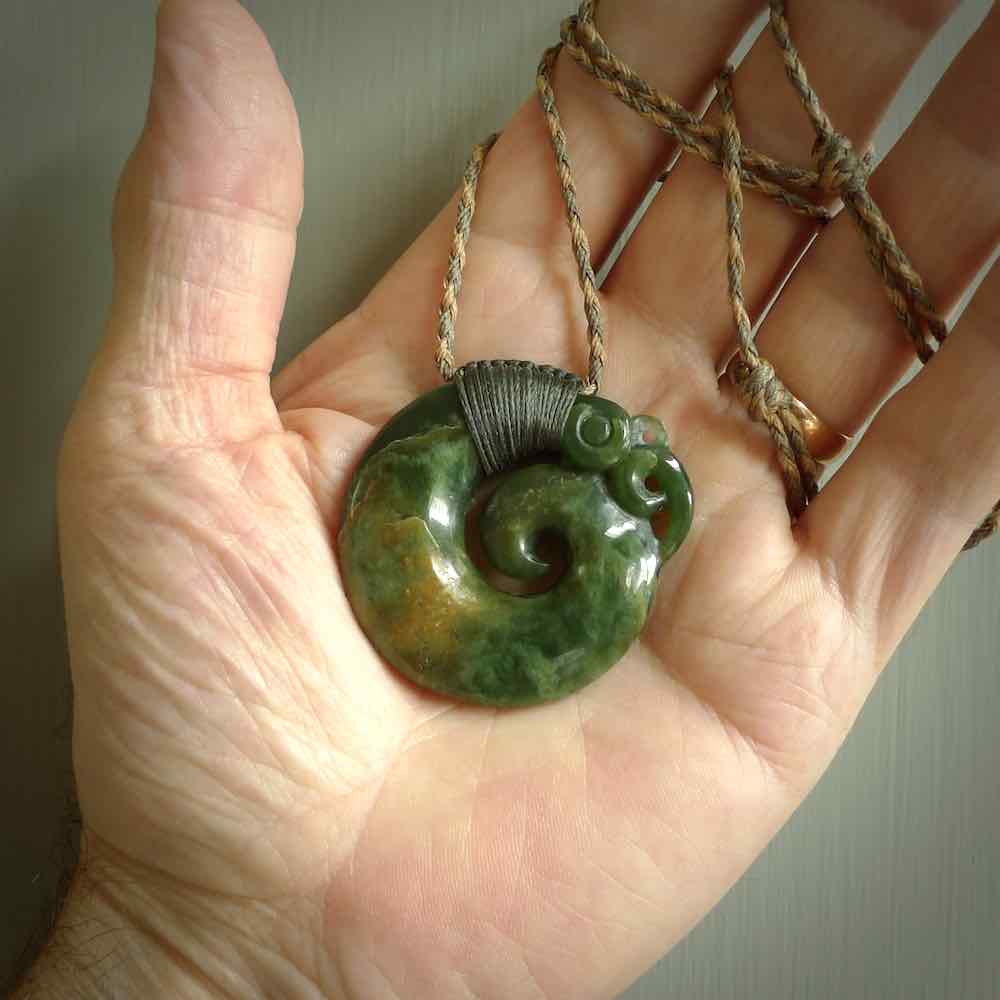 New Zealand Jade Koru Manaia. Hand carved maori pendant. Made in New Zealand. Real Jade, pounamu. Real New Zealand Jade Manaia with Koru necklace with a polished finish.