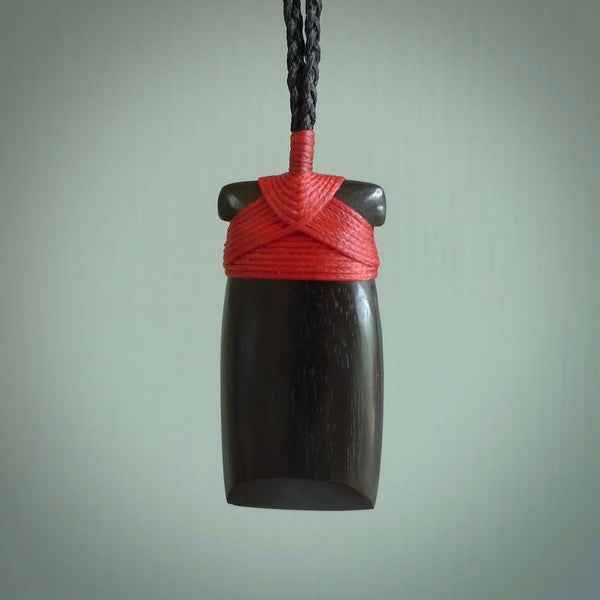 This photo shows wooden toki pendants. The cord is length adjustable which allows the pendant to be positioned where it suits you best. The toki was carved for us in hard wood. Unique art to wear.