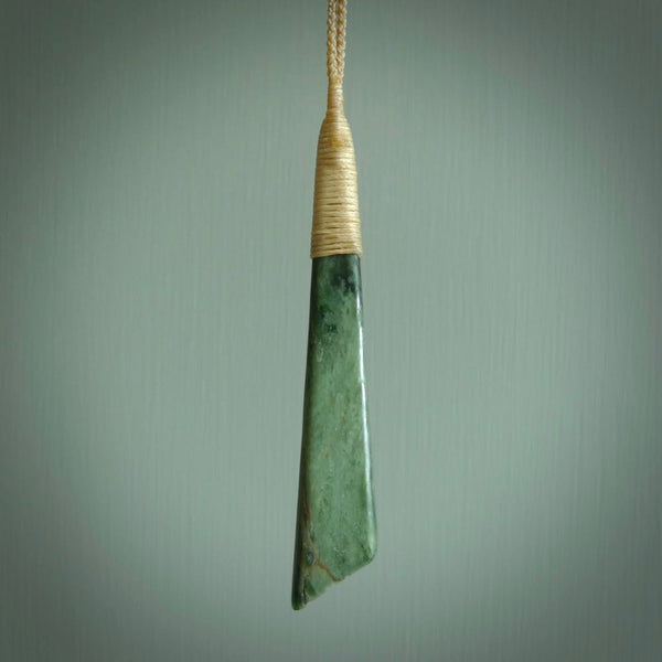 This photo shows a large jade drop shaped pendant. It a a lovely varied light and dark green New Zealand jade. The cord is a four plait beige and is adjustable in length. One only large, contemporary drop necklace from Jade, by Ric Moor.