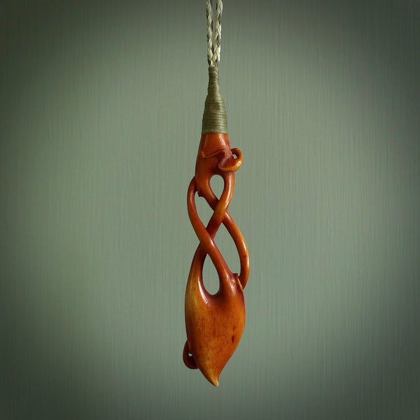 This pendant is carved from cow bone and stained with a homemade tea dye. It is a unique piece of wearable art that is sure to catch the eye. The shape is a complex twist form and has been beautifully hand carved by bone carver Yuri Terenyi.