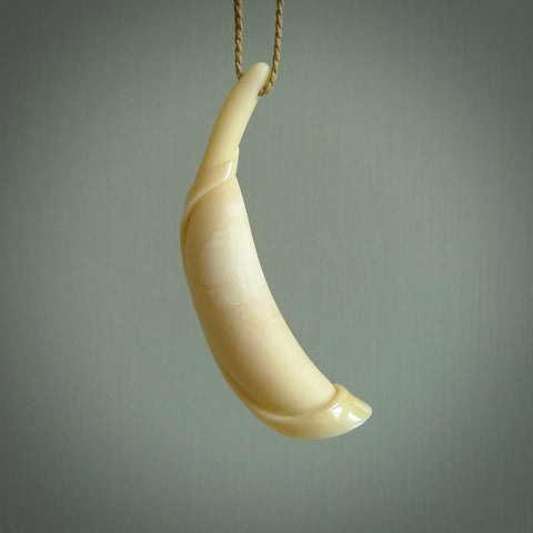 This is a large whale tooth lily pendant hand carved by Kerry Thompson. It is a beautiful creamy white colour and is a polished and matte finish.